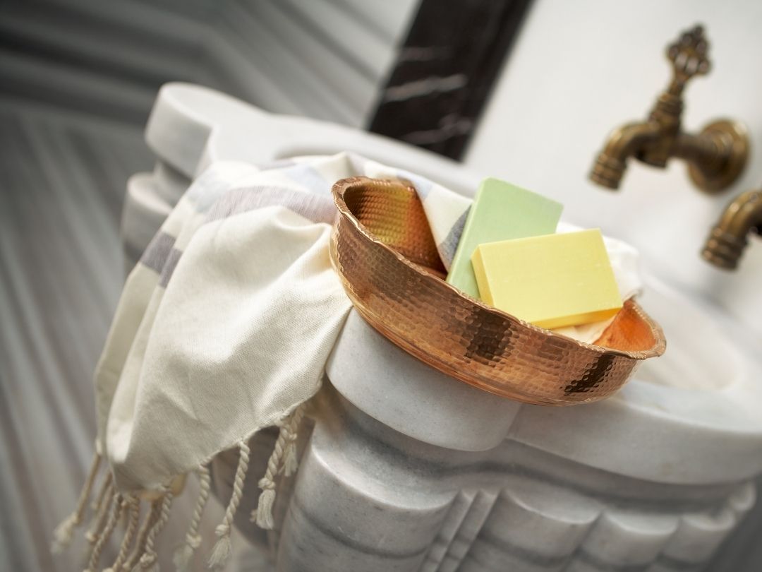 Traditional copper faucet and marble basin in a hammam